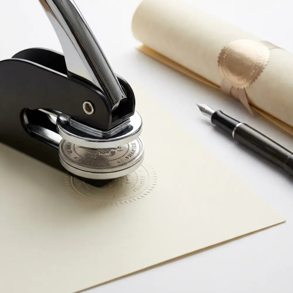 Stamper on a piece of paper with a fountain pen and rolled-up document in the background.
