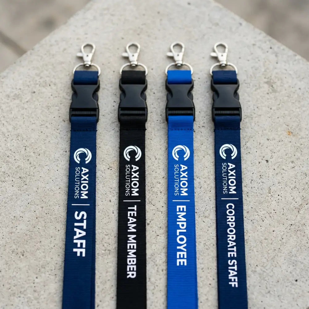 Four lanyards with different labels on a concrete surface