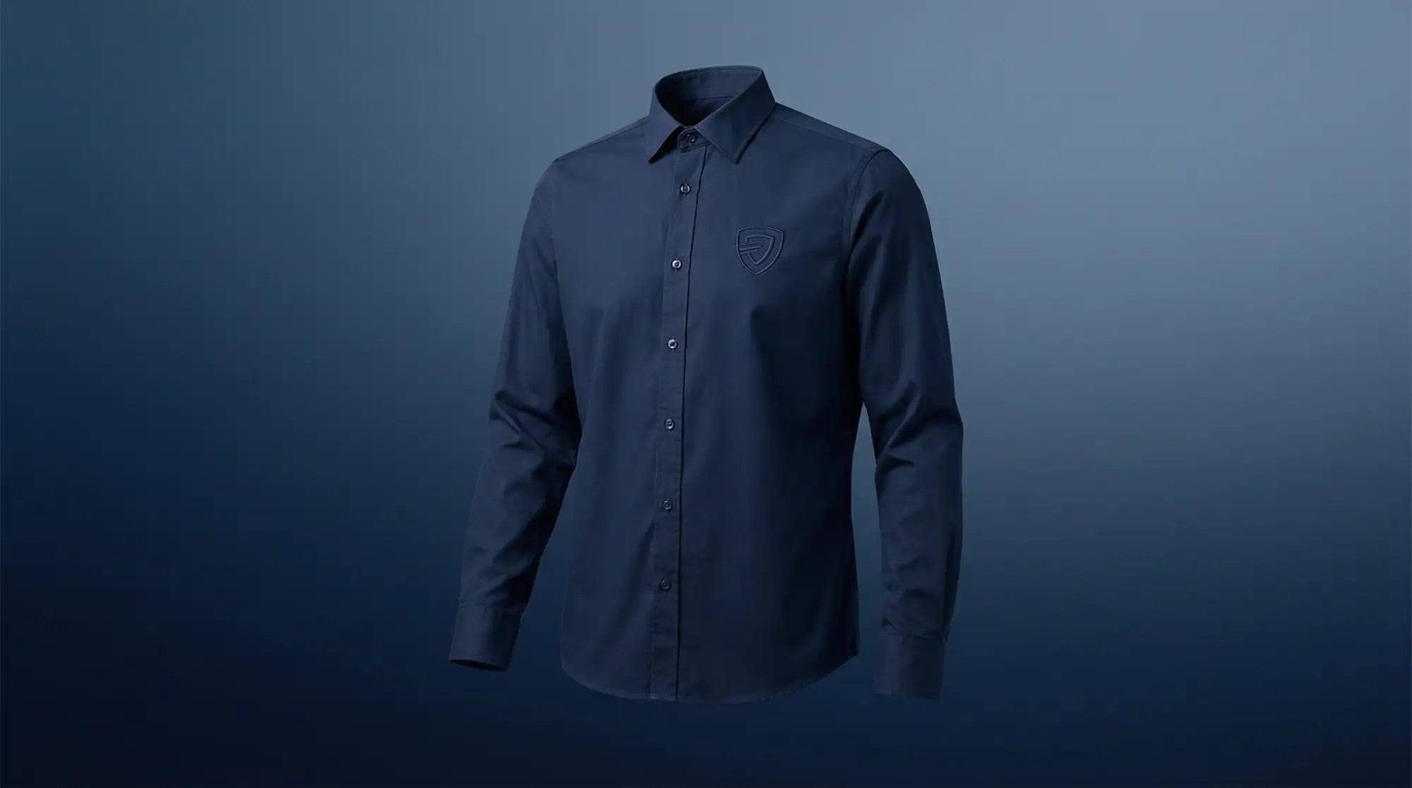 Dark navy blue long-sleeved button-down shirt with a subtle embroidered crest on the left chest.