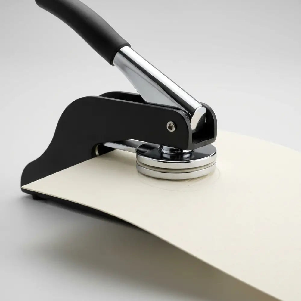 Black and silver leather punch tool on a white background