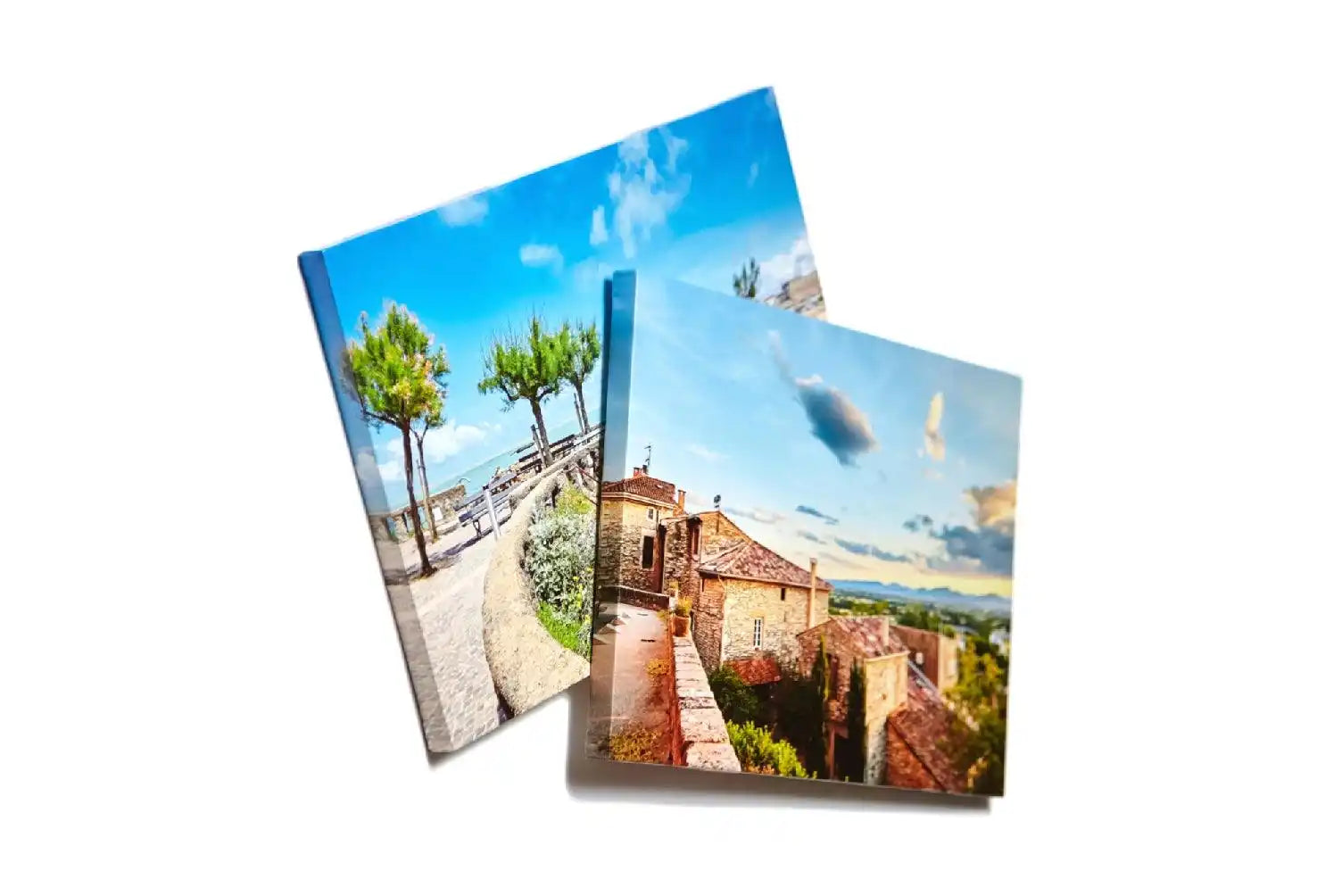 Two overlapping photo prints showing Mediterranean coastal and village scenes.